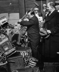 Fiorello La Guardia (1882-1947) smashing confiscated slot machines