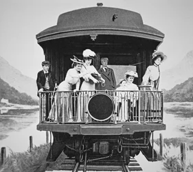 Tourists taking scenic photographs from the rear observation platform of a Union Pacific train