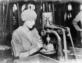 Woman countersinking detonator tube hole and filling hole in hand grenade at Westinghouse Electric & Mfg. Co., East Pittsburgh, Pa., during World War I
