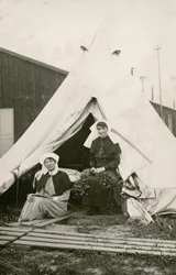 Sister Eleanor Wibmer Jeffries and Sister Nellie Constance Morrice (right) outside their tent at No. 3 Australian General Hospital with flowers picked from the bank of the Somme, c. June 1917