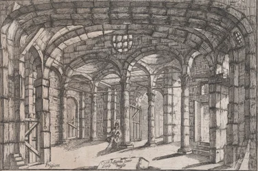 Interior of a prison in which sits a woman