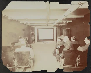 Cinephone Co. a theater at 124 E. 25th Street, with men seated in front of the movie screen