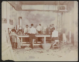 Film laboratories at Carlton Motion Picture Co. with five men and one woman working with film, New York