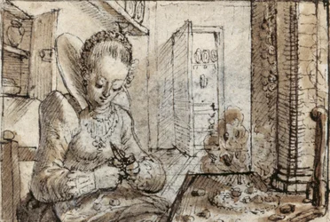 A fashionable young woman sits at a kitchen table to shell walnuts