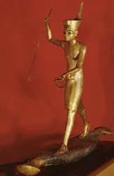 Tutankhamun standing on a flat boat and throwing a harpoon