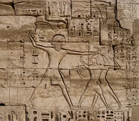 Egyptian antiquity: detail of reliefs celebrating the victories of the Pharaoh over the peoples of the sea. Funeral Temple of Ramses III (1187-1156 BC). Luxor, Medinet Habu, Egypt