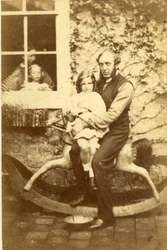 Father and Daughter Seated on a Rocking Horse with Brother and Mother Looking Through Window, 1860s