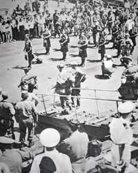 Kilted pipers play ashore from the 1st Battalion Argyll and Sutherland Highlanders from HMS Ceylon at Pusan, 29th August 1950