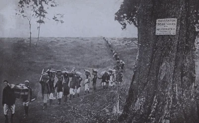 Line of men carrying goods from the equator to Selfridges, London