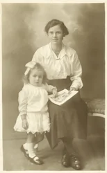 Pretty girl, mother or governess, showing photos to young child