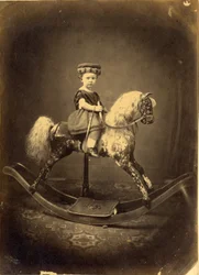 Young Girl Seated on a Dappled Rocking Horse
