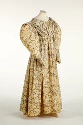 Dress printed with a flower and branch design on cream woven fabric with grid pattern in the weave, c.1830-35