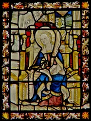 The east window depicting St Faith carrying her emblem the saw