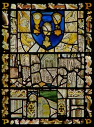The east window depicting a shield with emblems of the Sacrament; fragments of canopy with figures