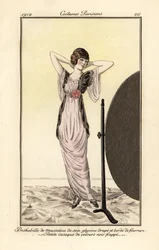 Woman in lilac muslin silk dress with black velvet vest looking at herself in a mirror