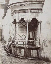 A man drinking from a corner fountain, on a street in Damascus, Syria