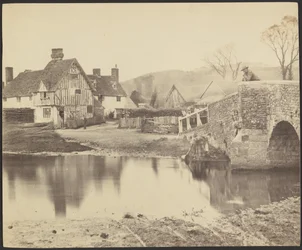 View of a House across a River with a Bridge to the Right