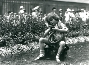 A Young Girl Betty Holding an Eastern Indigo Snake, While Sitting on a Leather Trunk, London Zoo, 1924