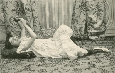 Girl, lying on the floor, holding a ball above her head