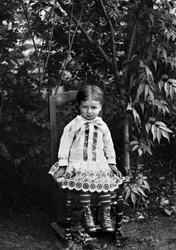 Portrait of a little girl from Bourmont in Haute Marne, sitting in the garden of the Abbey of Septfontaines. Photography late 19th century. Ducos Collection.