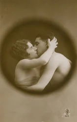 Young man and woman kissing as viewed through a peephole