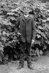 Young man has a cigarette, employed as a man to do everything, posing in the garden of the Abbey of Septfontaines, near Bourmont in Haute-Marne, around 1880. Photography. Ducos Collection.