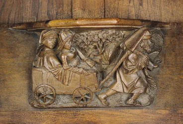 Carving depicting a couple in a cart pulled by a man, from a choir stall