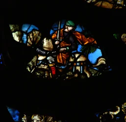 The west rose window depicting a scene from the Book of Revelation: A man on another horse with a sword to take peace from the earth