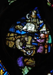 The west rose window depicting a scene from the Book of Revelation: Time of harvest. Son of man with a sickle on a white cloud