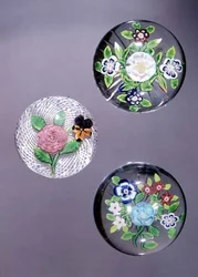Three paperweights: Clichy rose and pansy with opaque white latticinio ground, and two Baccarat bouquets with star cut bases