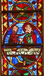 Window w213 depicting a scene from the life of St Thomas: the saint at a marriage banquet for the daughter of the king of India has his face slapped by a cupbearer