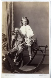 Young girl sitting on a rocking horse
