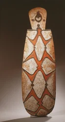 Oval Asmat Shield, Carved in Relief with Stylised Figures, a Mask at the Top