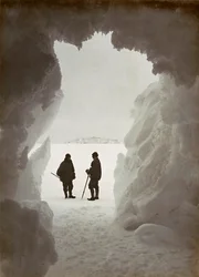 Men outside a cave carved out of the ice during an expedition to Antarctica