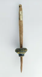 Spindle whorl with its surviving wooden spindle (from Hallstatt, Iron Age)