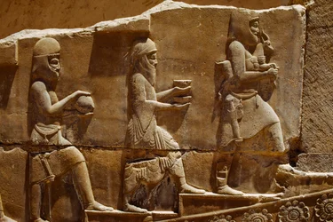 Relief sculpture of men carrying offerings on the walls of Persepolis. Persepolis, Iran.