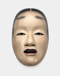 A wood mask with gofun ground, painted with sumi for the hair, eyes and teeth and red for the lips