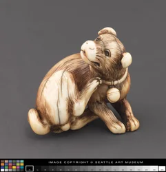Netsuke modeled as a dog scratching its neck