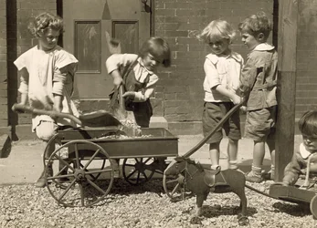 Young Children Loading Gravel into a Cart