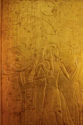 Gold shrine surrounding sarcophagus depicts Goddess Isis