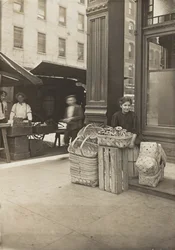 Lena Lochiavo, 11 years old, basket and pretzel seller, at Sixth Street market in front of saloon entrance, Cincinnati, Ohio, August 1908
