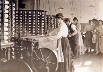 Young women working at a spinning machine in a cotton mill, South Carolina, 1908