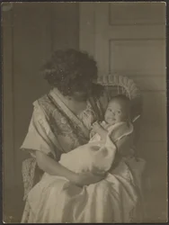 Florence Holding Baby in Rocking Chair