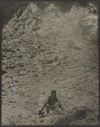 Man Crouching in Rocky Landscape