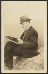 Man Reading Magazine on Rock