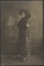 Portrait of Woman in Long Coat before Tapestry