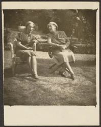 Two Women Seated in Lawn Chairs