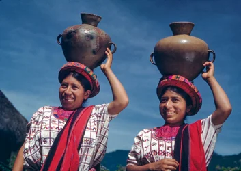 Guatemalan women carrying water jugs in the village of Nebaj, Guatemala