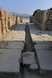 Minoan archeological site of Phaistos. Wide corridor with a drainage duct