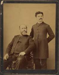 [Unidentified bearded man seated with unidentified man with moustache standing]